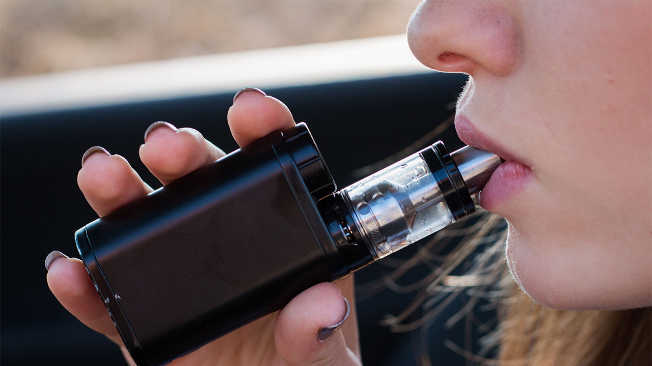 Woman Vaping behind the wheel